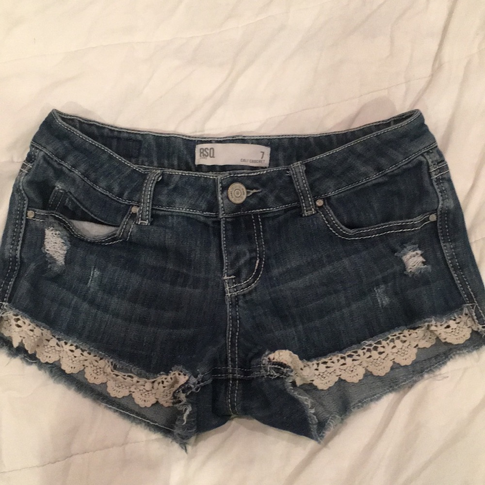 Blue jean shorts with lace at the bottom.
